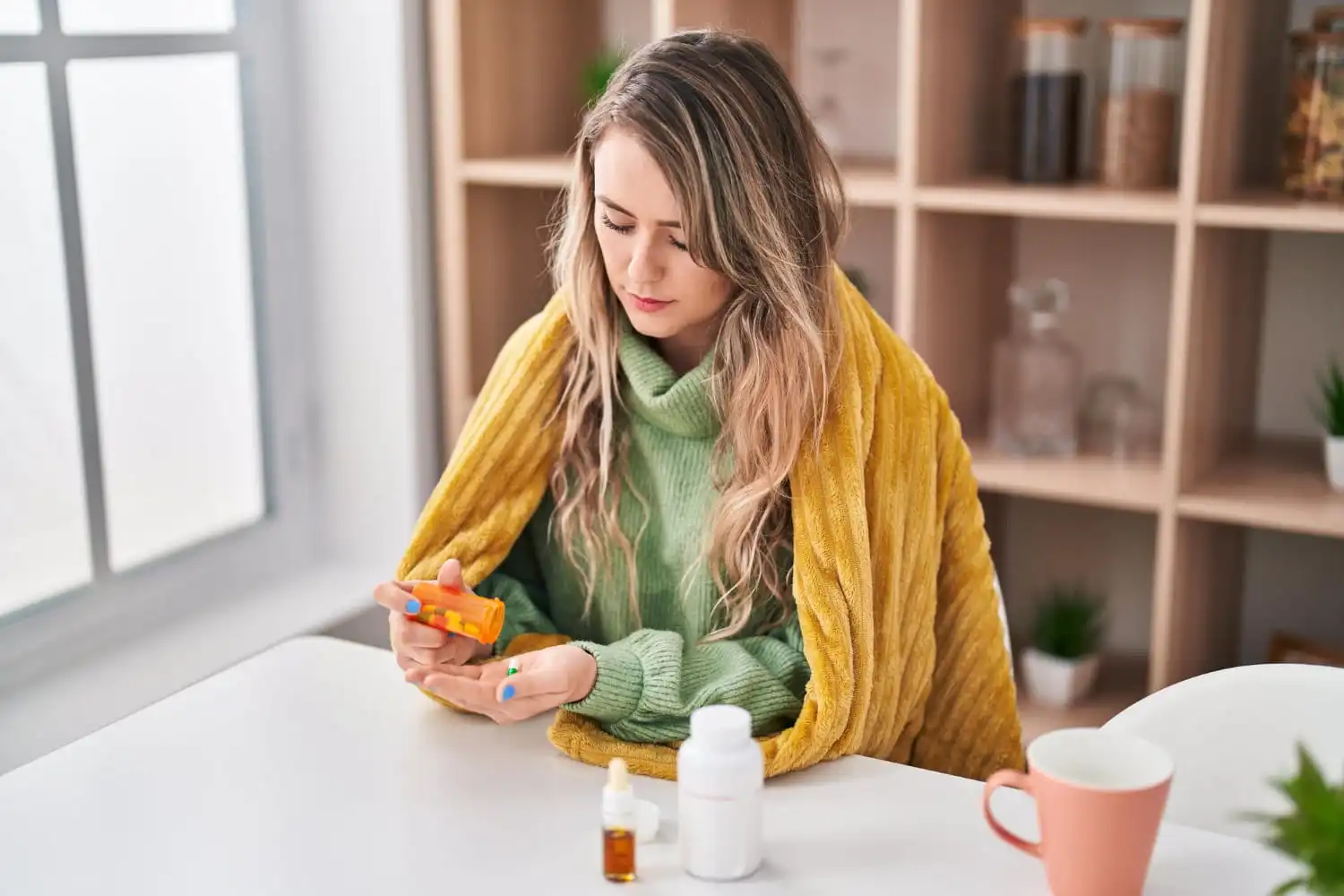 Person managing seasonal allergy symptoms with natural remedies such as herbal tea, saline nasal rinse, and indoor air purification.