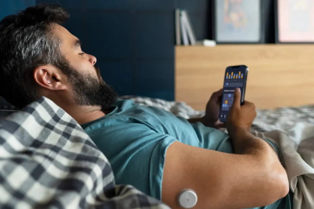 Person wearing a sleep tracking device while a mobile app displays sleep duration, sleep stages, and health monitoring data.