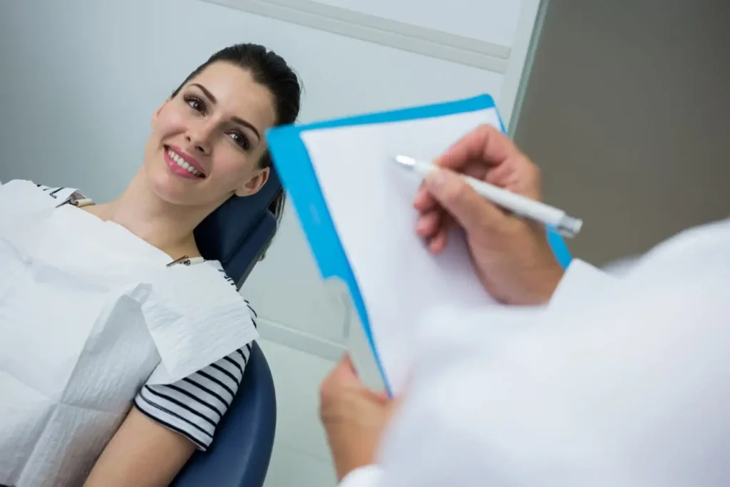 Patient attending a routine dental checkup while a dentist examines teeth and discusses preventive oral healthcare.