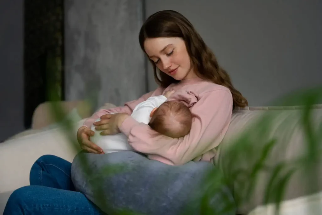 Mother breastfeeding her newborn in a calm, comfortable setting, highlighting the importance of exclusive breastfeeding during the first six months of life.