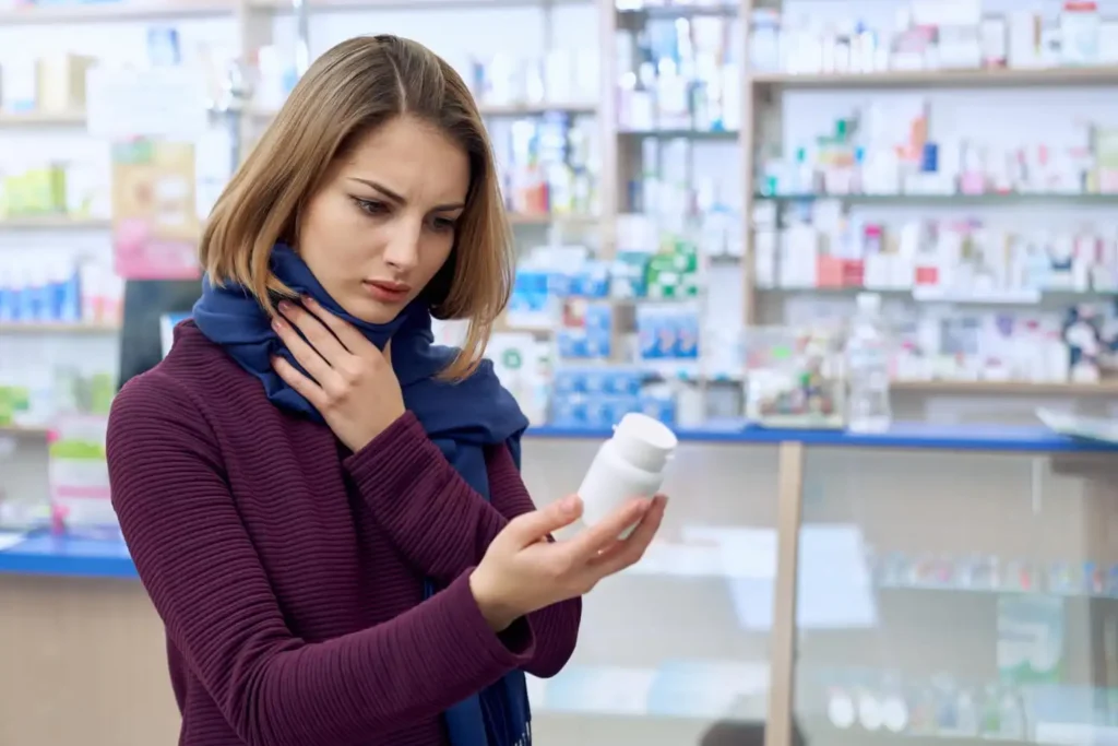 Person carefully reading a medicine label on a prescription bottle, highlighting dosage instructions, warning symbols, expiry date, and storage information.