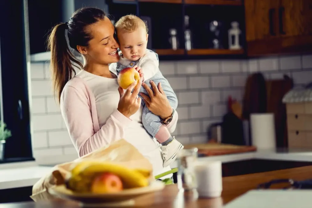 Breastfeeding mother enjoying a balanced meal with fruits, vegetables, whole grains, dairy, and water to support healthy nutrition during breastfeeding.